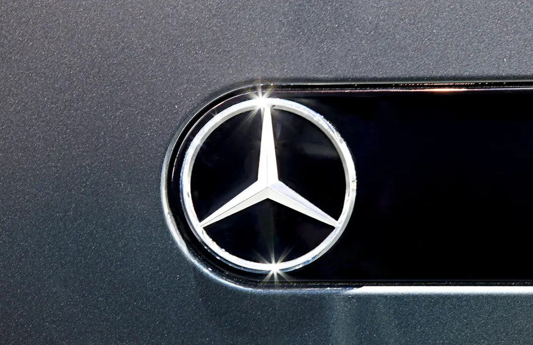 Close-up of the Mercedes-Benz star badge on a grey car